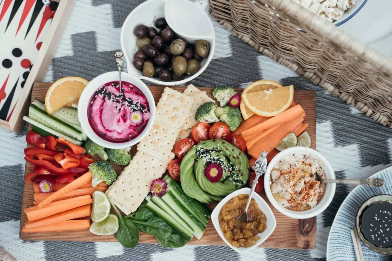 A table of vegan foods, salads and fruits from a top down perspective